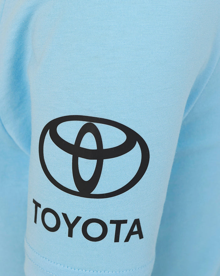 Close-up of light blue fabric with a large Toyota logo on the chest