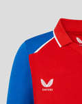 Close up of red junior T20 shirt with blue shoulder panel and white piping, featuring the England crest and Castore logo.