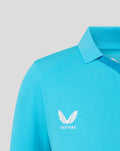 Shoulder close up of a bright blue cricket shirt with white Castore wing logo.