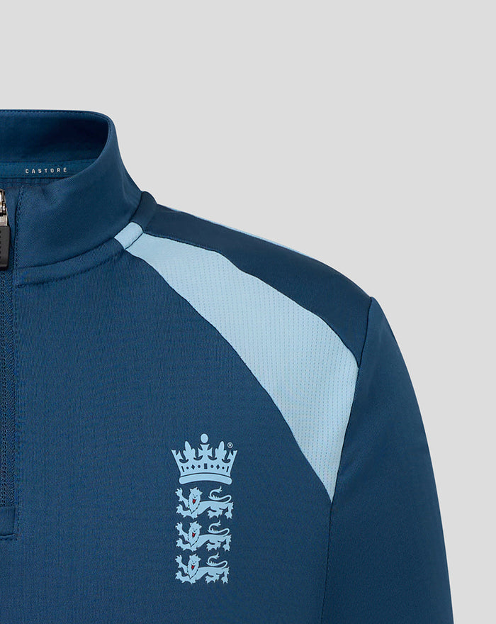 Close-up of a dark blue Junior Training Midlayer with a light blue shoulder panel and the Three Lions crest on the chest