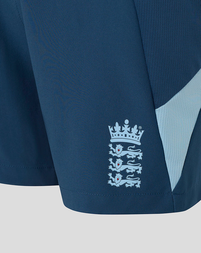 Close-up of blue junior shorts showing the Three Lions crest near the hem.