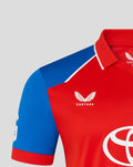 Chest close-up of red T20 Pro shirt with a white crest and blue sleeve.