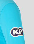 Close up of blue ODI long sleeve shirt sleeve with a KP logo patch.