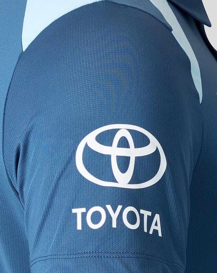 Sleeve close up of blue polo featuring Toyota logo