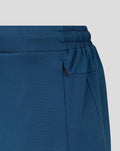 Close-up of the blue training pants waistband with elastic band and zip pocket detail.