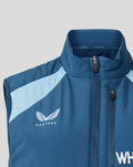 Close up of blue sleeveless training gilet with zipper, England crest on the chest and light blue shoulder panel