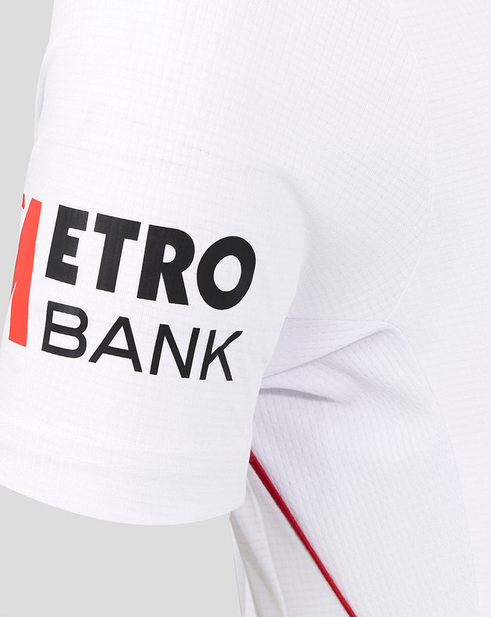 Left sleeve close-up with Metro Bank branding in bold black letters on white fabric with red piping along the seam
