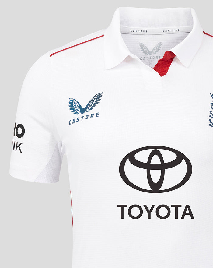 Front view of white cricket jersey with Castore logo on chest and Toyota sponsor and red shoulder piping.