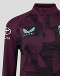 Close up of ECB 1/4 zip training top showing light blue Castore wing logo on purple geometric fabric.
