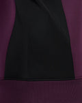 Close-up of ECB training sweatshirt showing black center panel with blackberry wine side panels and ribbed hem