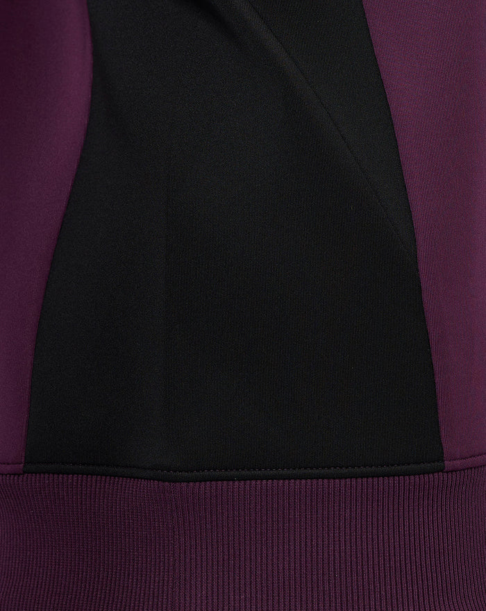 Close-up of ECB training sweatshirt showing black center panel with blackberry wine side panels and ribbed hem