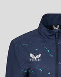 Close-up of navy Yorkshire Graphic Track Jacket collar with front zipper and white Castore wing logo amid turquoise splatter.