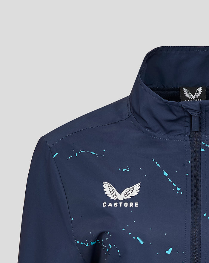 Close-up of navy Yorkshire Graphic Track Jacket collar with front zipper and white Castore wing logo amid turquoise splatter.