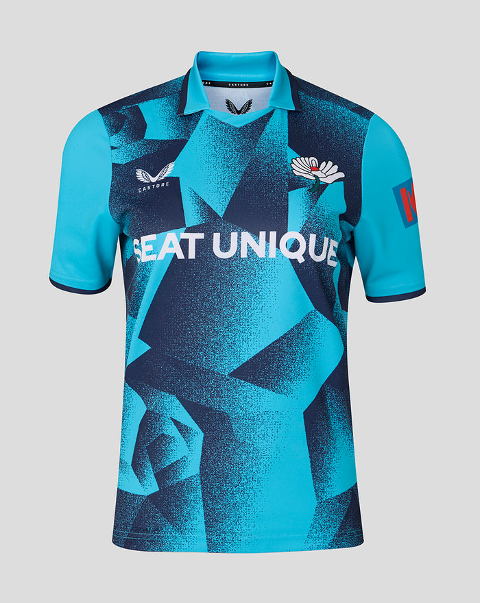 Turquoise and navy short sleeve cricket jersey with bold geometric pattern and SEAT UNIQUE across the front