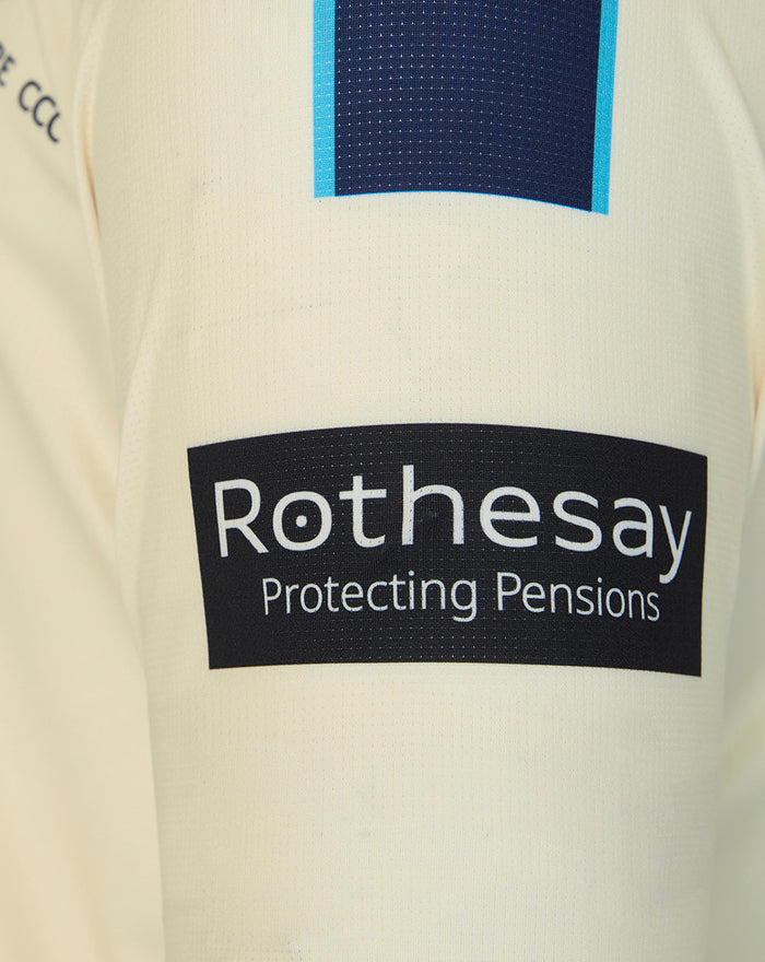 Cream County Championship jersey sleeve close-up with Rothesay sponsor patch.