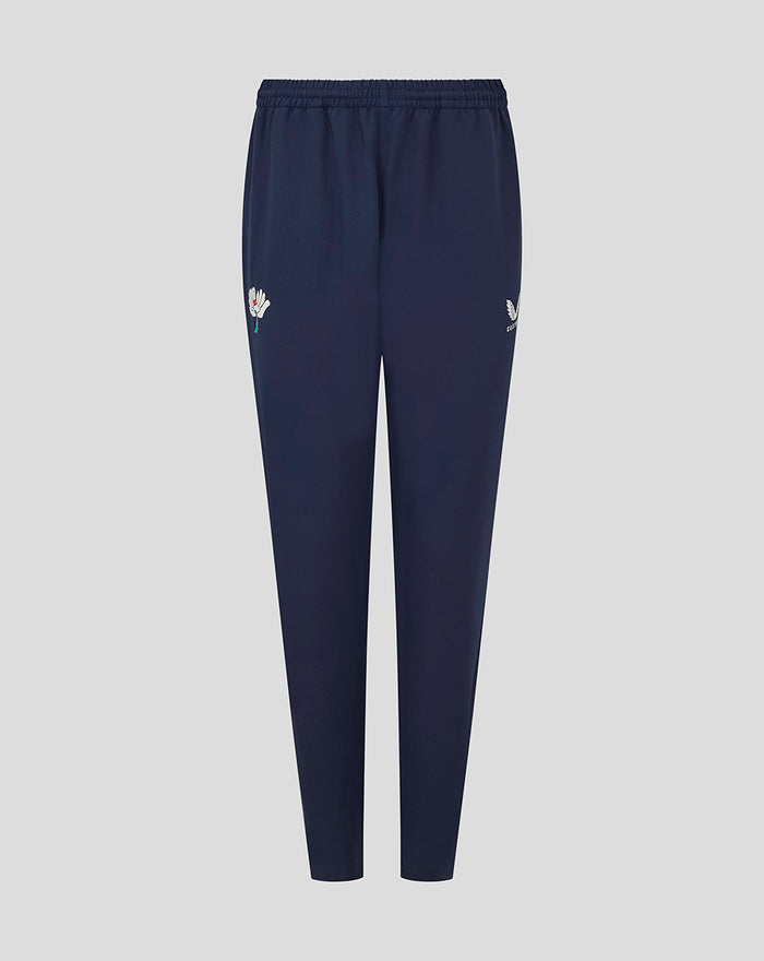 Navy Yorkshire track pants with a white flower emblem on the left thigh and a small wing logo on the right thigh