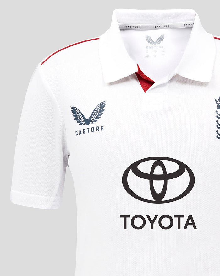 Close-up of the white ECB Junior Test Replica shirt collar and upper chest with red inner placket and Toyota logo.
