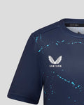 Close up of navy jersey upper front showing Castore logo and turquoise splatter pattern.
