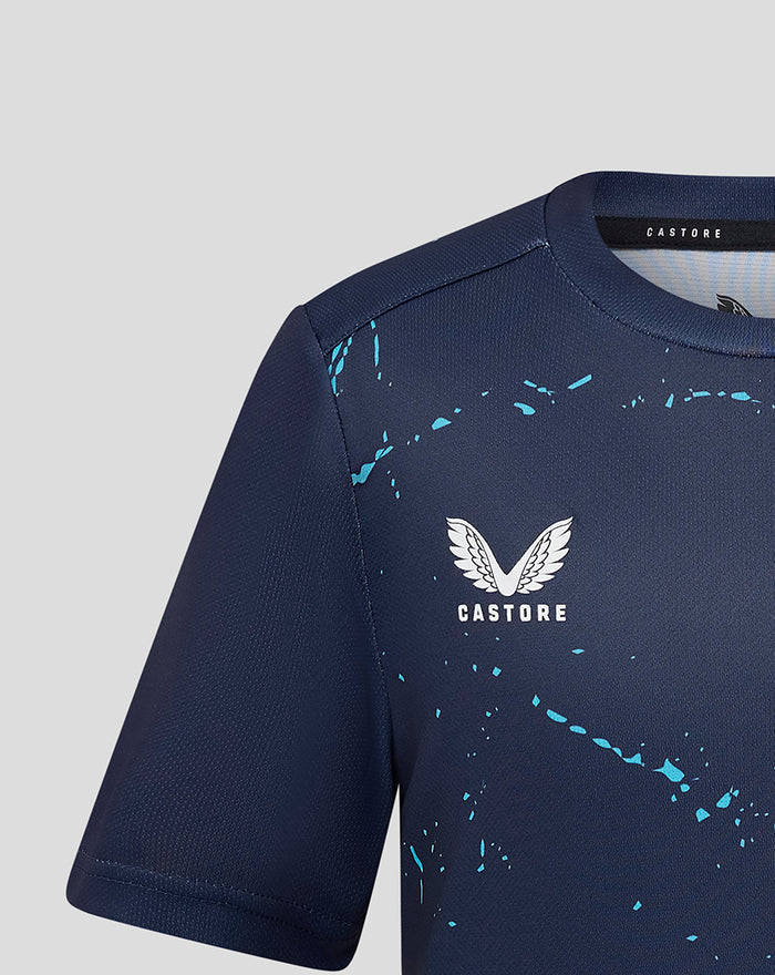 Close up of navy jersey upper front showing Castore logo and turquoise splatter pattern.