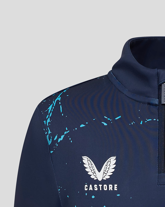 Close-up of navy juniors Yorkshire graphic 1/4 zip top with blue paint splatter and Castore emblem