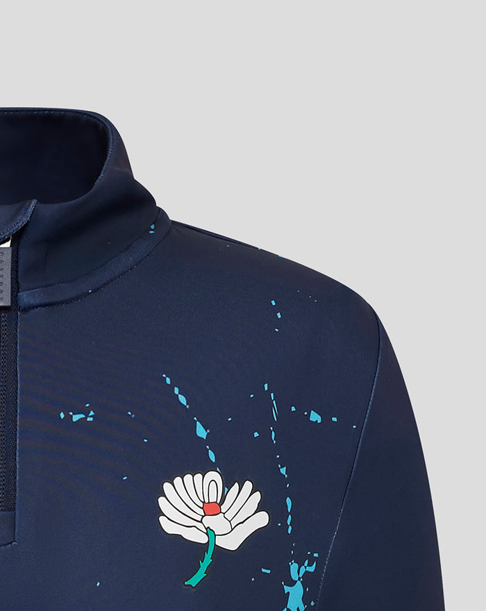 Front chest of navy Yorkshire graphic top with Castore wing logo and white flower emblem amid blue splatters