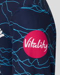 Detail of navy junior T20 short sleeve jersey with blue crackle pattern and a pink Vitality sponsor circle on the sleeve area