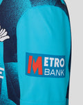 Close-up of bright blue sleeve with Metro Bank patch on the Junior 26/27 OD Short Sleeve Jersey Aqiarius.