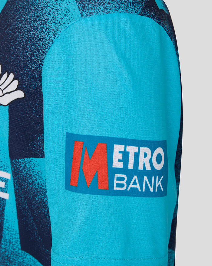 Close-up of bright blue sleeve with Metro Bank patch on the Junior 26/27 OD Short Sleeve Jersey Aqiarius.