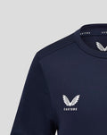 Close up of left chest shows white Castore wing logo on navy training tee.