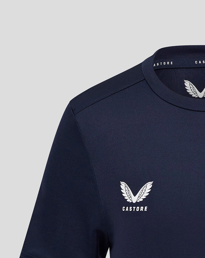 Close up of left chest shows white Castore wing logo on navy training tee.