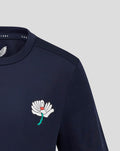 Navy juniors training tee with a large white floral emblem on the left chest.