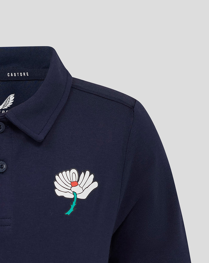 Navy juniors polo with a white flower crest on the left chest and a Castore label at the collar.