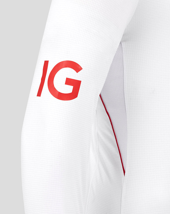 Close-up of white sleeve with bold red IG lettering on the upper arm.