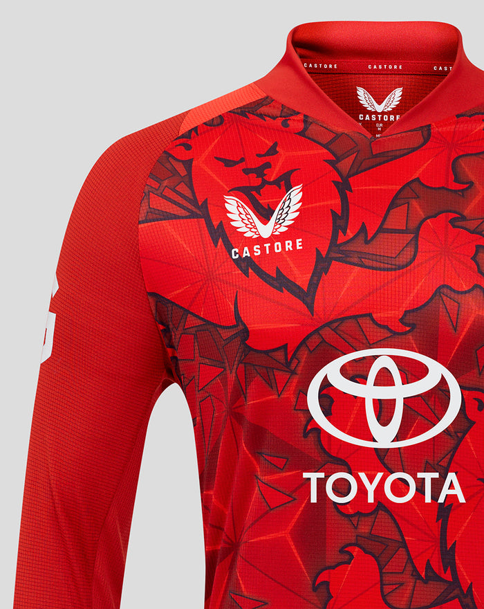 Close up of red T20 Pro long sleeve shirt featuring bold graphic print Three Lions crest and Toyota logo.