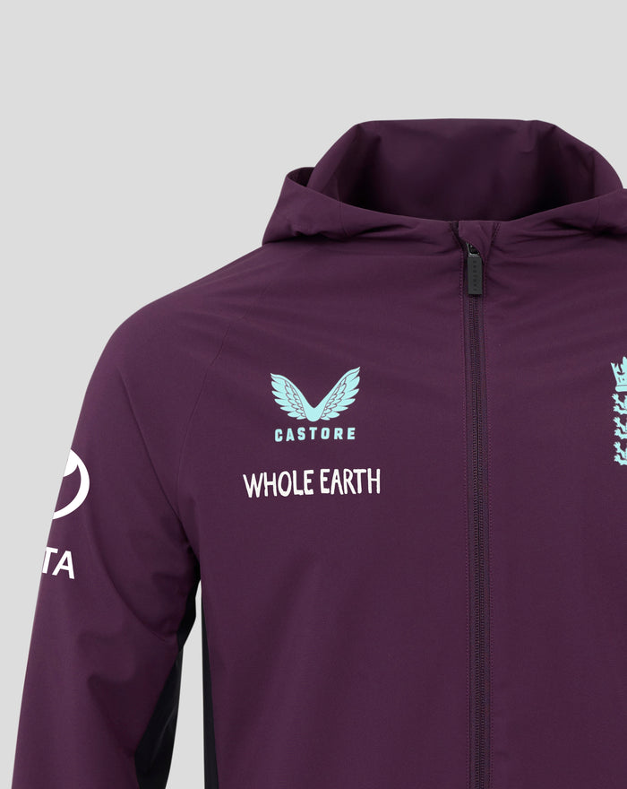 Upper chest close-up of the purple jacket showing Whole Earth text and light blue crest near the zipper