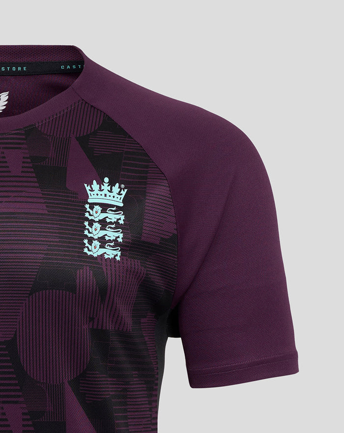Close up of ECB men's training short sleeve tee in blackberry wine purple with a geometric print and pale blue England crest.