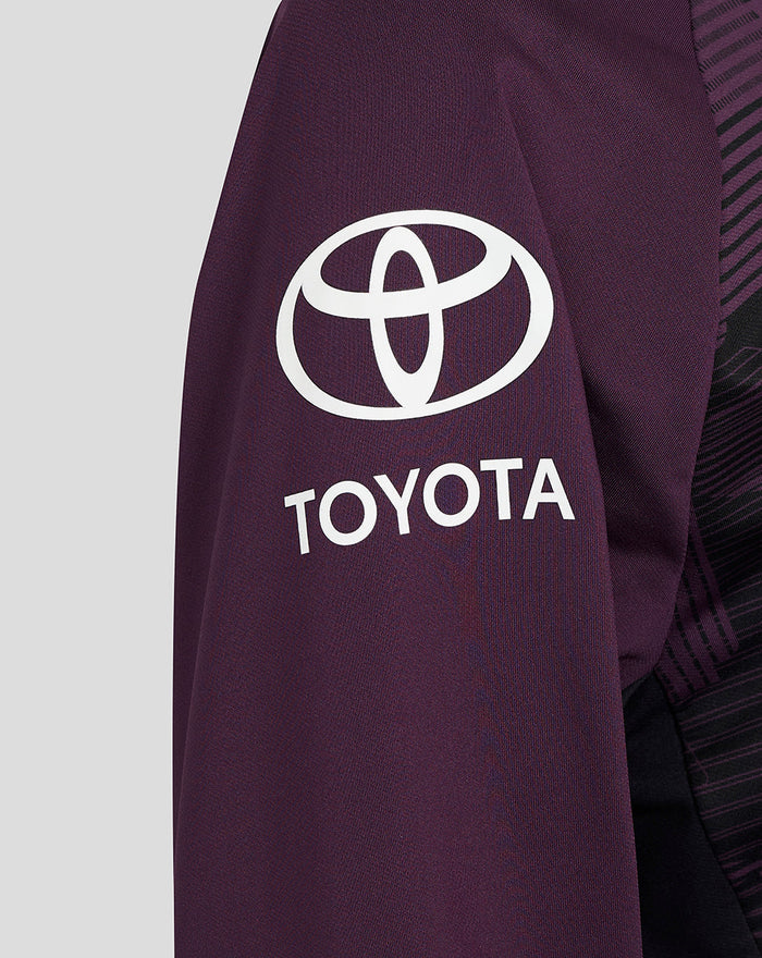 Left sleeve close-up of purple training top with white Toyota emblem.