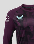 Close-up of shoulder on ECB Training Tee showing the light blue Castore logo on purple patterned fabric