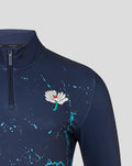 Shoulder and chest close-up of navy Yorkshire Graphic Performance 1/4 Zip Top with turquoise splatter and white flower emblem near the zipper