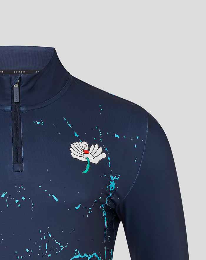 Shoulder and chest close-up of navy Yorkshire Graphic Performance 1/4 Zip Top with turquoise splatter and white flower emblem near the zipper