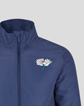 Close-up of navy jacket collar and shoulder with crest on left chest and visible zipper.