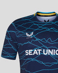 Close-up of navy T20 jersey chest showing teal wave lines and SEAT UNIQUE across the front.