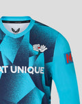 Shoulder and chest view of the blue geometric overshirt with crest emblem and Metro Bank patch on the sleeve