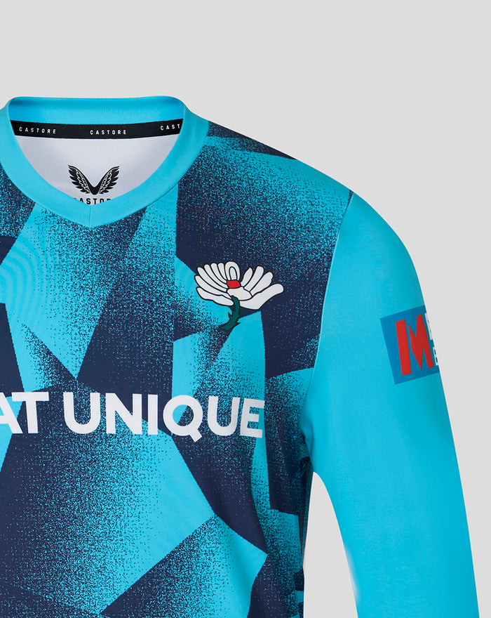 Shoulder and chest view of the blue geometric overshirt with crest emblem and Metro Bank patch on the sleeve