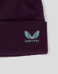 Close up of purple ECB training bobble hat with teal Castore logo on ribbed cuff